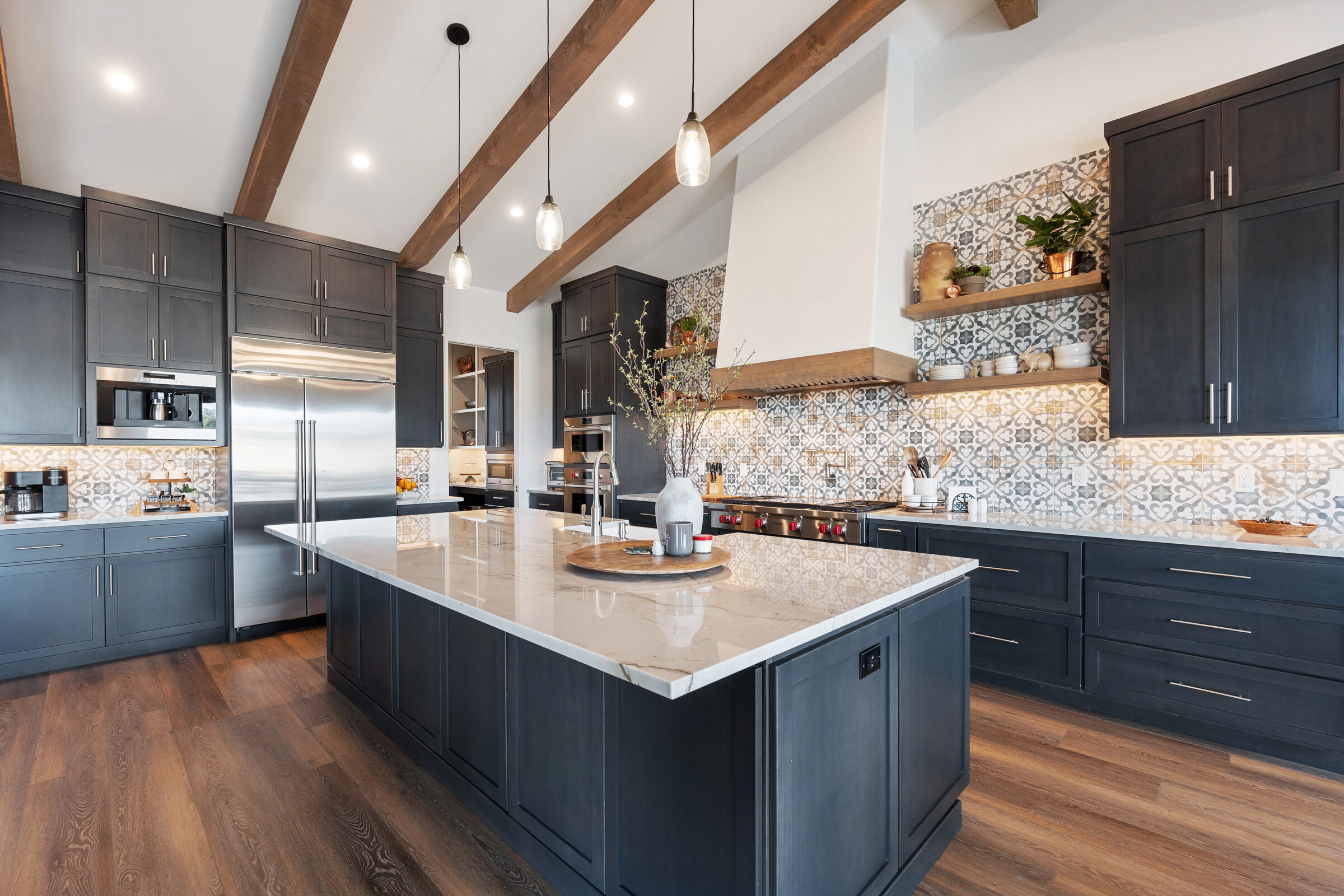 Premium kitchen with custom-style dark cabinetry, a large stone island, and refined finish details